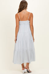 woman wearing a light blue striped tiered maternity dress, shown from the back with adjustable straps