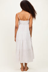 woman wearing a striped tiered maxi dress with adjustable spaghetti straps, view from the back
