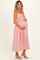 woman wearing a pink and white striped maternity dress with spaghetti straps and holding her baby bump