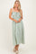 woman wearing a green and white striped maxi dress with spaghetti straps and a smocked bodice