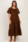 woman wearing a brown maternity maxi dress with short puff sleeves and tiered ruffle details