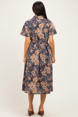 woman wearing a navy floral midi dress with short sleeves and a belted waist, viewed from the back
