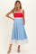 woman wearing a red and light blue color block maternity dress with pockets and a flowy skirt