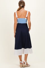 woman wearing a navy and white colorblock maternity dress with a smocked bodice, showing her back