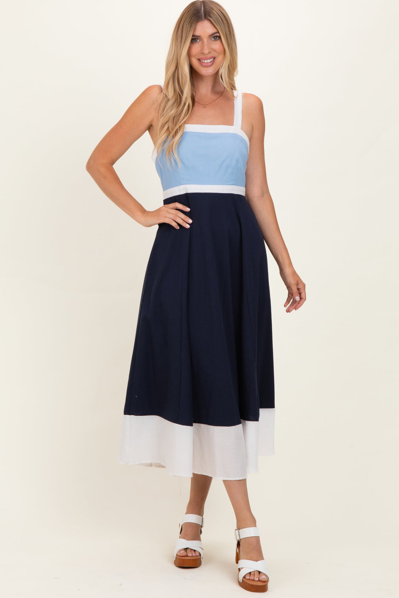 woman wearing a blue and navy color block maxi dress with a fitted bodice and flowy skirt