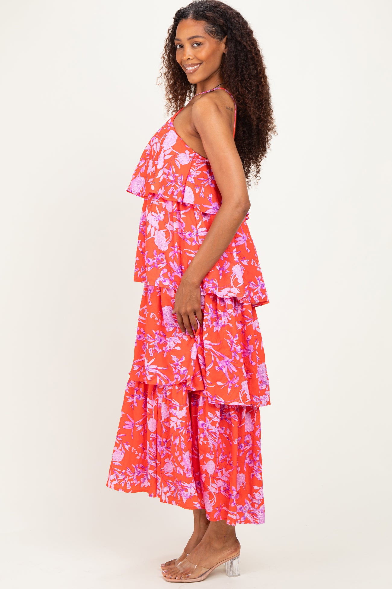 woman wearing a red floral tiered maxi dress with ruffled layers and a flowing silhouette