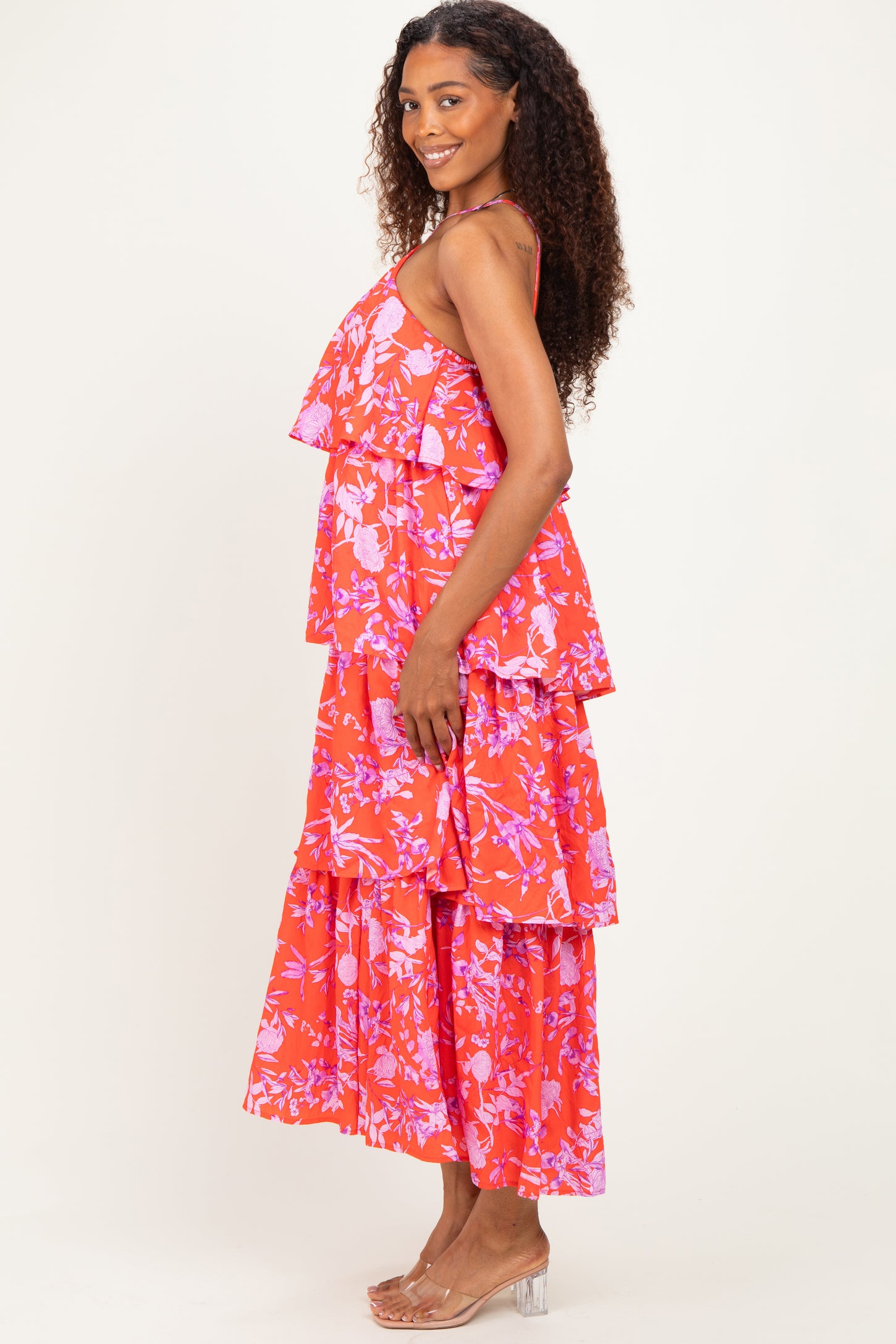 woman wearing a red floral tiered maxi dress with ruffled layers and a flowing silhouette