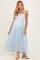 woman wearing a blue and white striped maternity maxi dress with floral bodice and bow straps, showing her baby bump
