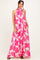 woman wearing a long flowy maxi dress with a pink floral print and a halter neck design