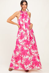 woman wearing a halter neck pink floral maxi dress with a flowy silhouette