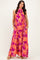 woman wearing a bright pink maxi dress with orange floral print and pockets