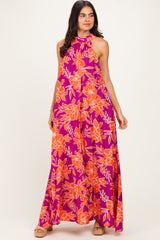 woman wearing a purple floral maxi dress with orange flowers and a halter neck design