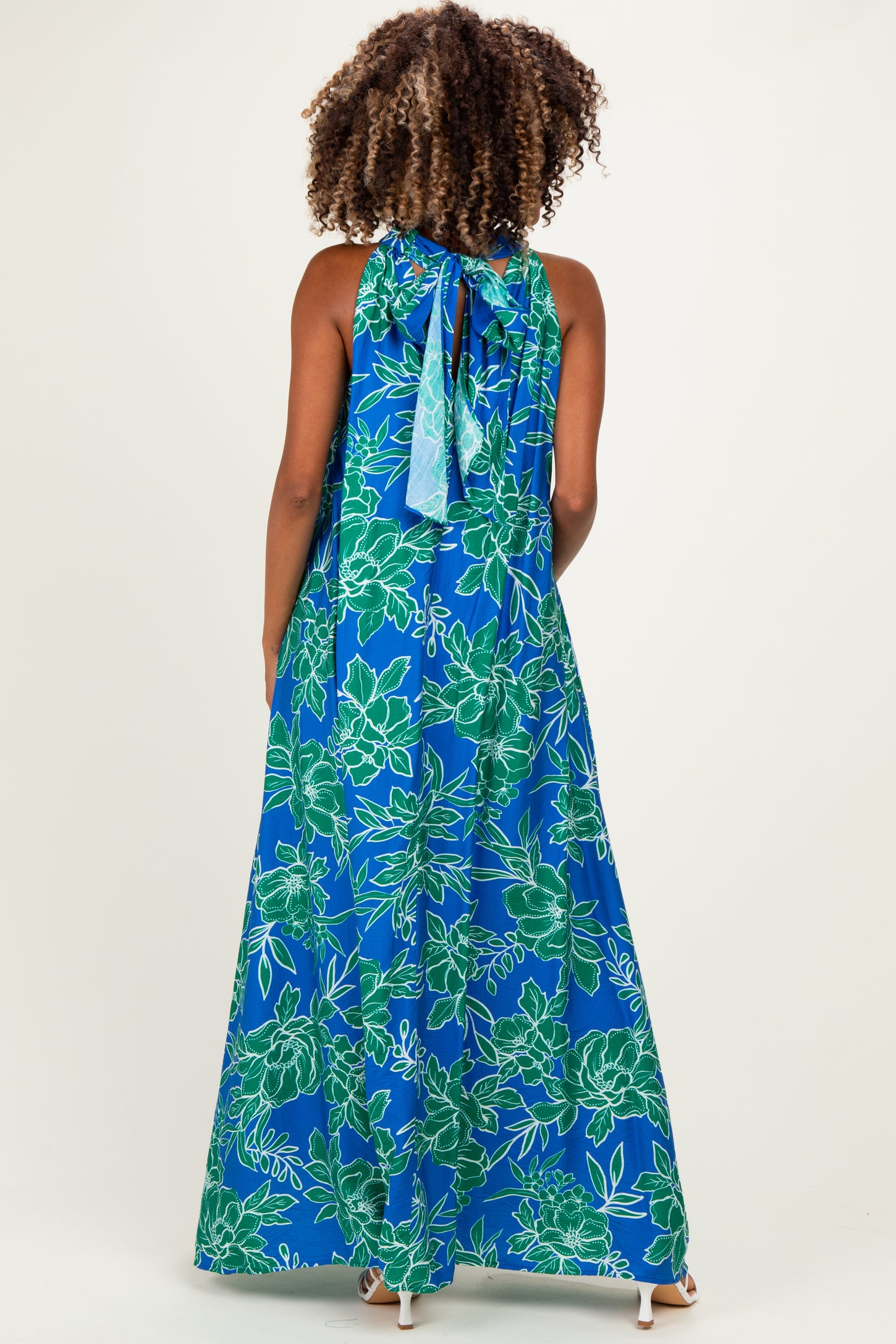 maternity wear blue maxi dress with green floral print and halter neck tie, shown from the back