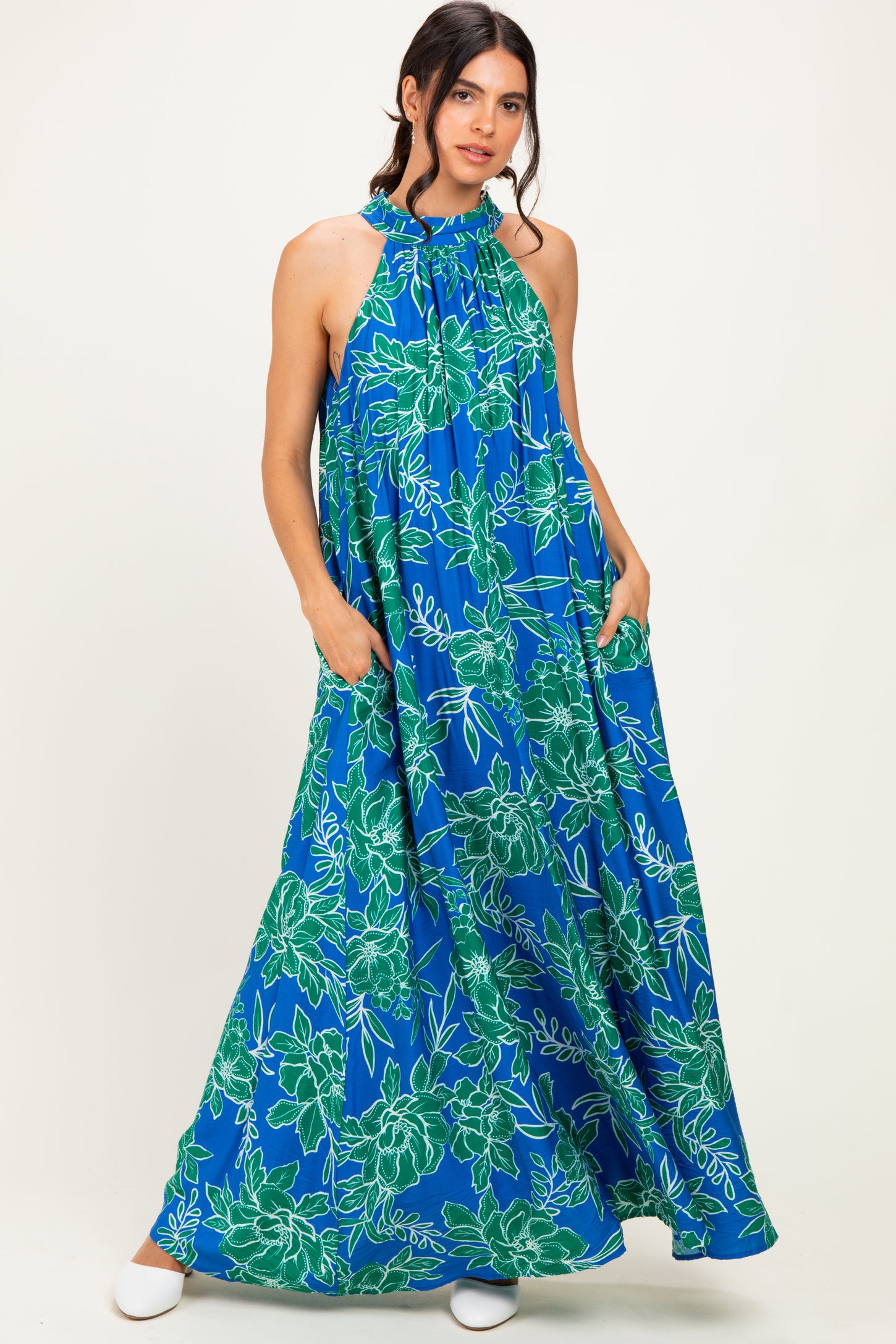 woman wearing a halter neck blue floral maxi dress with pockets