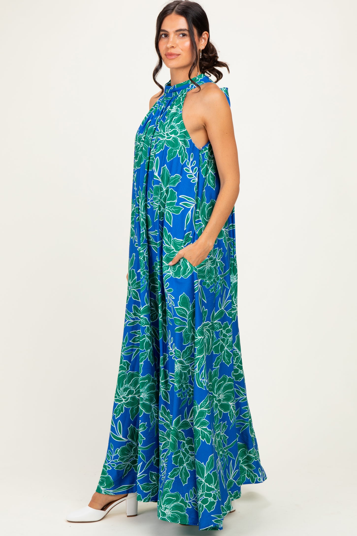woman wearing a blue floral halter neck maxi dress with pockets and loose fit