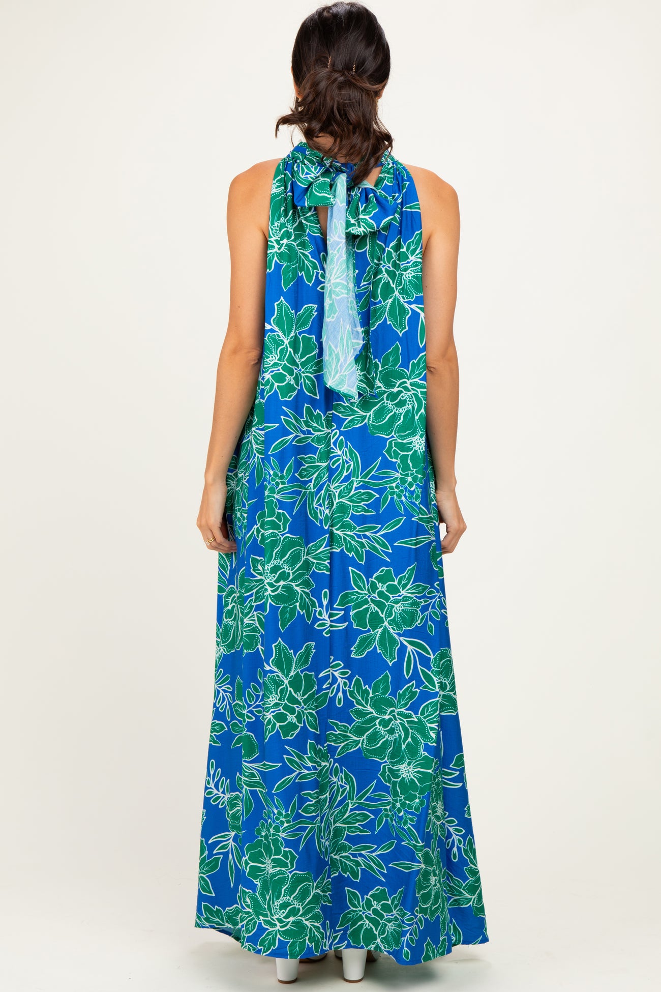 woman wearing a blue floral maxi dress with a halter neckline and open back view