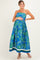 woman wearing a strapless blue floral maternity maxi dress and cradling her baby bump