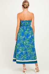 woman wearing a blue floral strapless maternity maxi dress with smocking and a flowy hemline