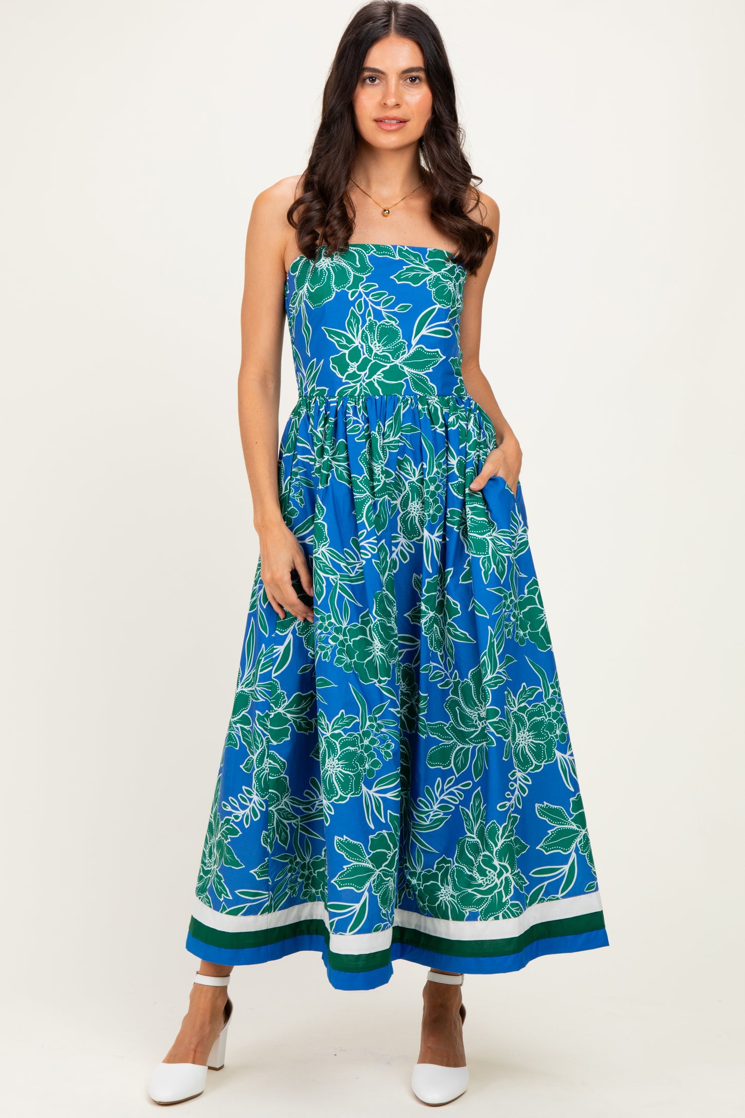 woman wearing a blue floral maxi dress with a strapless design and pockets