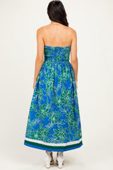 woman wearing a strapless blue floral maxi dress with smocked bodice and back ties, shown from the back