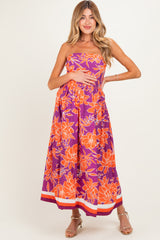 woman wearing a purple floral strapless maternity dress with a baby bump visible