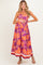 woman wearing a purple floral strapless maternity dress with a baby bump visible