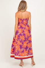 woman wearing a vibrant floral strapless maxi dress with smocked bodice, showing a flowing silhouette, maternity wear
