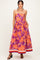 woman wearing a strapless purple maxi dress with orange floral print and pockets, standing in a relaxed pose