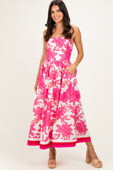 woman wearing a strapless pink floral maxi dress with an elastic waist and side pockets
