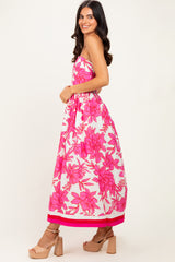 woman wearing a strapless maxi dress with bold pink floral print and a pink trim at the hem