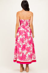 woman wearing a strapless pink floral maxi dress with a smocked bodice and a flared skirt, seen from the back