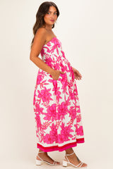 woman wearing a strapless pink floral maternity dress with pockets and a flowy silhouette