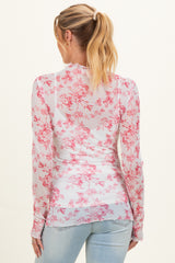 woman wearing a sheer white maternity top with pink floral print and long sleeves, seen from the back
