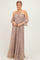 woman wearing a strapless blush maxi dress with ruffled off-the-shoulder sleeves and textured fabric.