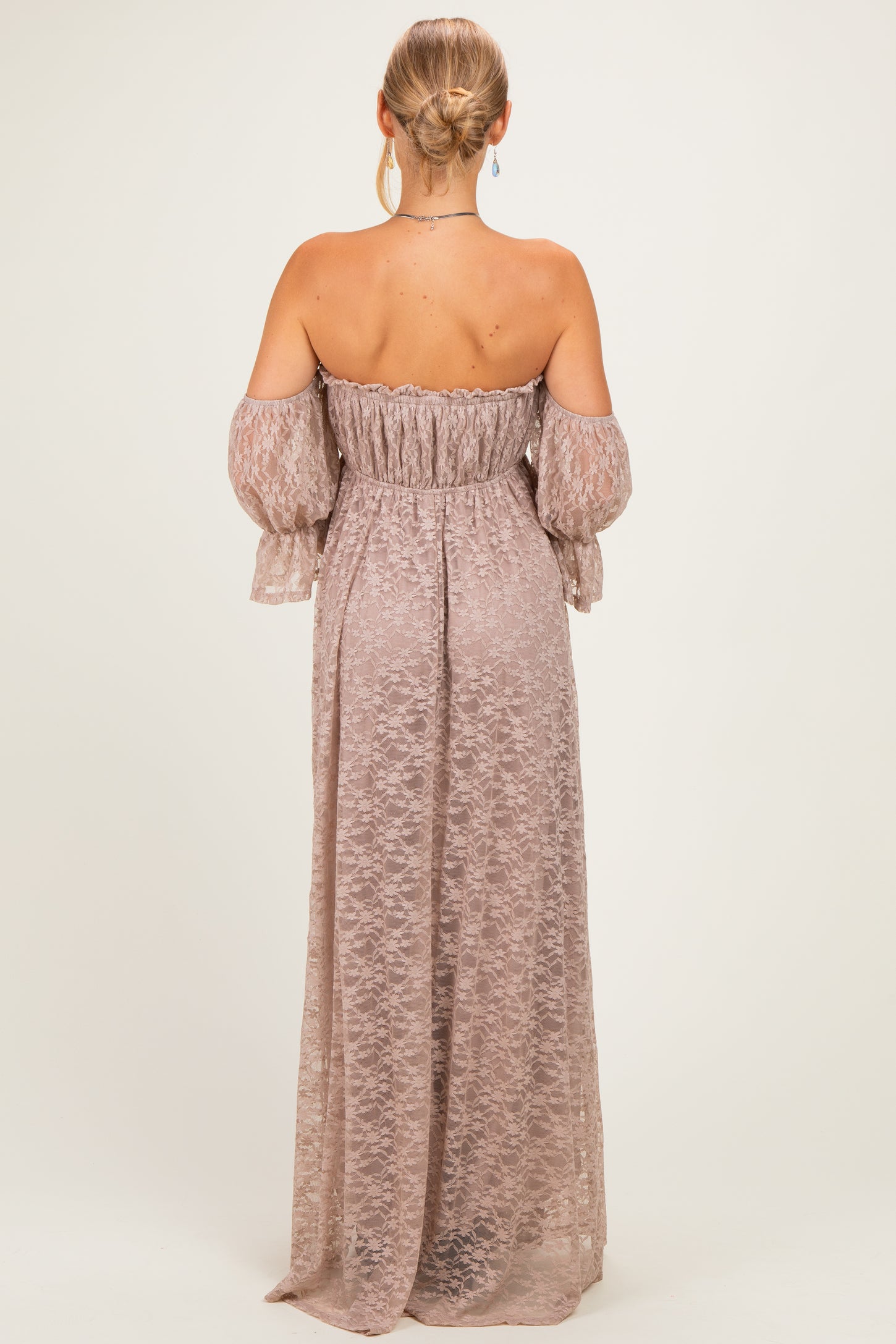 woman wearing a mauve off-the-shoulder maxi dress with long bell sleeves and a fitted waist