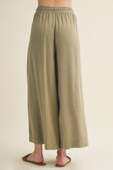 woman wearing olive green wide-leg pants with an elastic waistband, viewed from the back