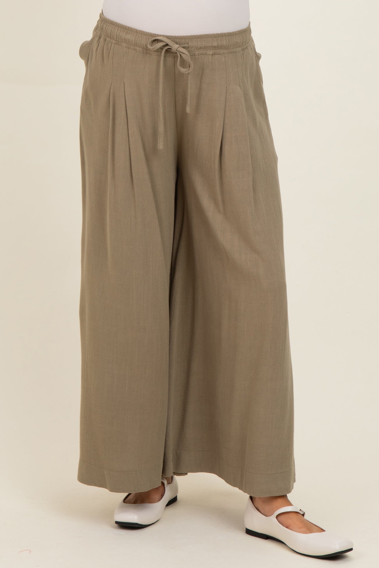 woman wearing olive green maternity wide-leg pants with a drawstring waist and pleated details