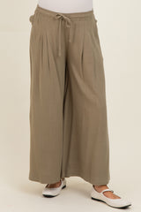 woman wearing olive green maternity wide-leg pants with a drawstring waist and pleated details