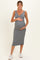 woman wearing a grey ribbed maternity dress and holding her baby bump