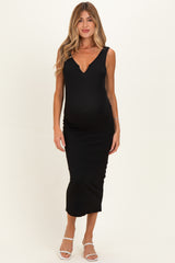woman wearing a black ribbed maternity dress with a v-neckline and a visible baby bump