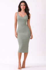 woman wearing a form-fitting olive green ribbed midi dress with a v-neckline and spaghetti straps