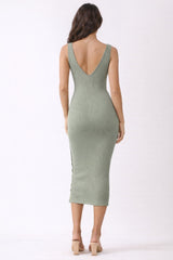 woman wearing a ribbed olive green midi dress with a deep v-back and side slit, styled with open-toe heels