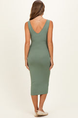 woman wearing a green ribbed midi maternity dress with a deep v-back, showing her back and arms