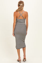 woman wearing a striped gray and black maternity dress with crisscross straps, showing a form-fitting style from the back