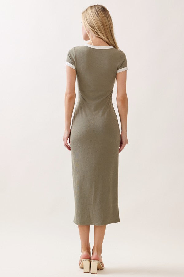 woman wearing a fitted olive green midi dress with white trim and short sleeves, shown from the back