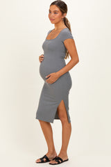 woman wearing a gray ribbed maternity dress with a side slit and holding her baby bump