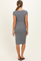 woman wearing a gray form-fitting maternity dress with short sleeves and a knee-length cut, seen from the back