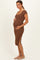 woman wearing a brown ribbed maternity dress with short sleeves and side slits, highlighting her baby bump