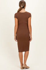 woman wearing a brown fitted maternity dress with short sleeves, showing a sleek, simple design from the back