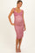 woman wearing a pink floral maternity dress with ruffled straps and a fitted silhouette, showcasing her baby bump